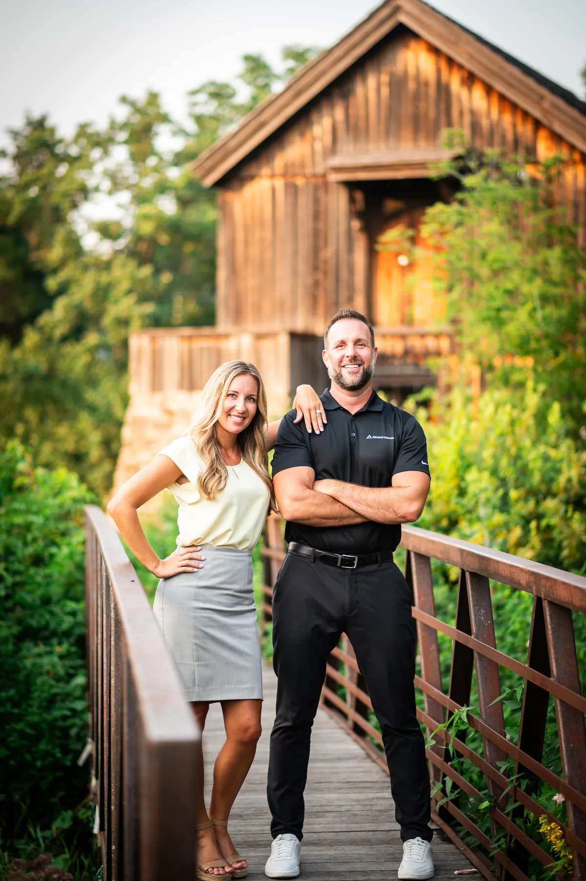 Joe and Serenity Almond standing together on an outdoor bridge near Rockford